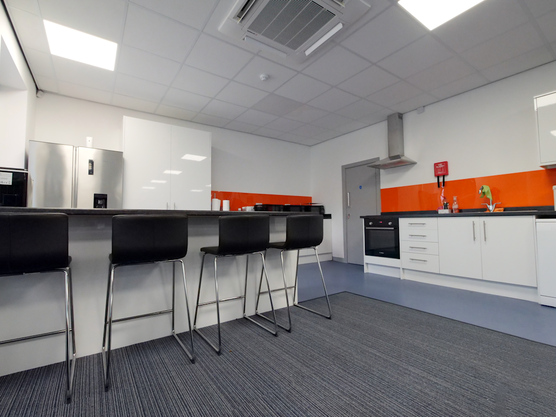 Küchenbereich der Location mit Arbeitsfläche, Stauraum und Beleuchtung.